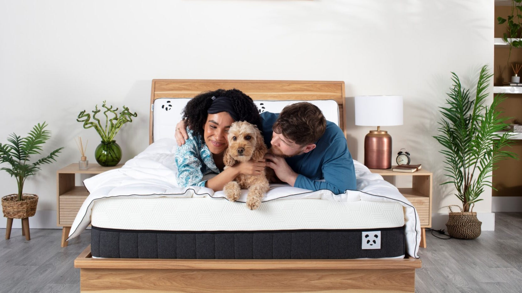 Couple with a dog laying on Panda Hybrid Mattress Pro