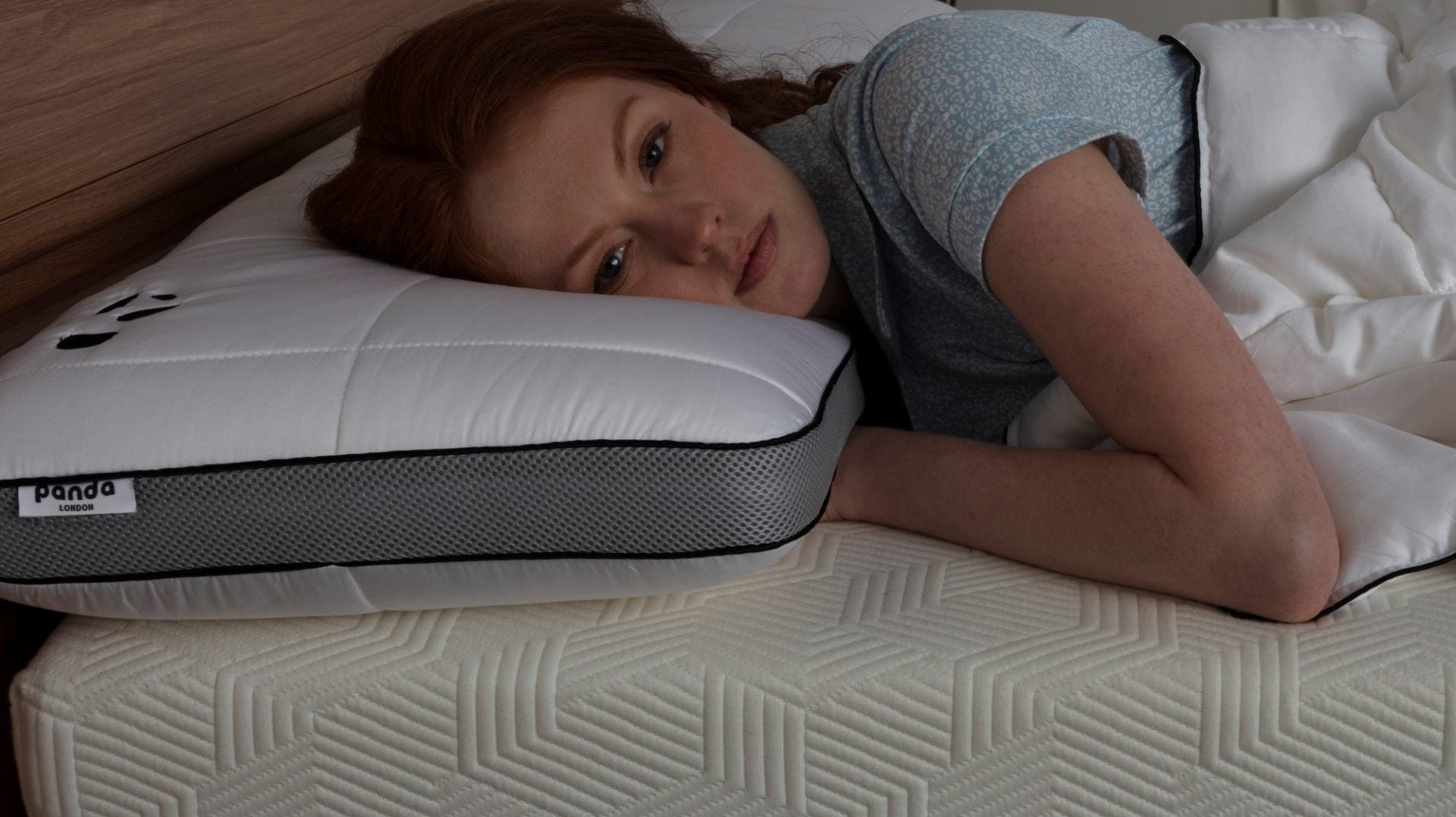 Woman lying on a Panda London mattress, showcasing comfort for quicker sleep.
