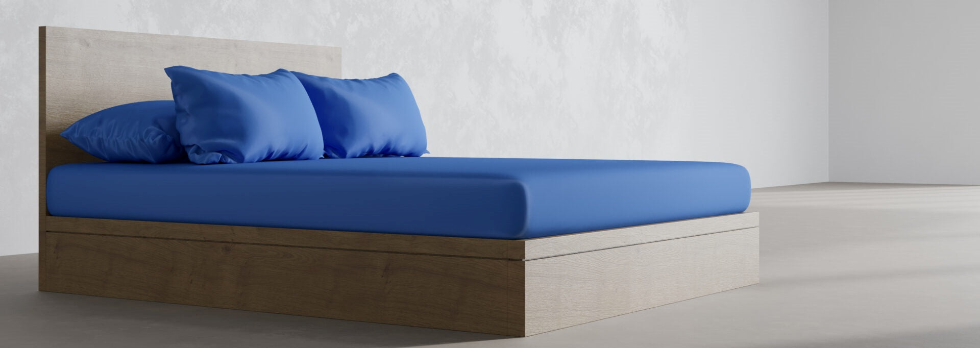 Modern bed with blue sheets and pillows in a minimalist bedroom setting.