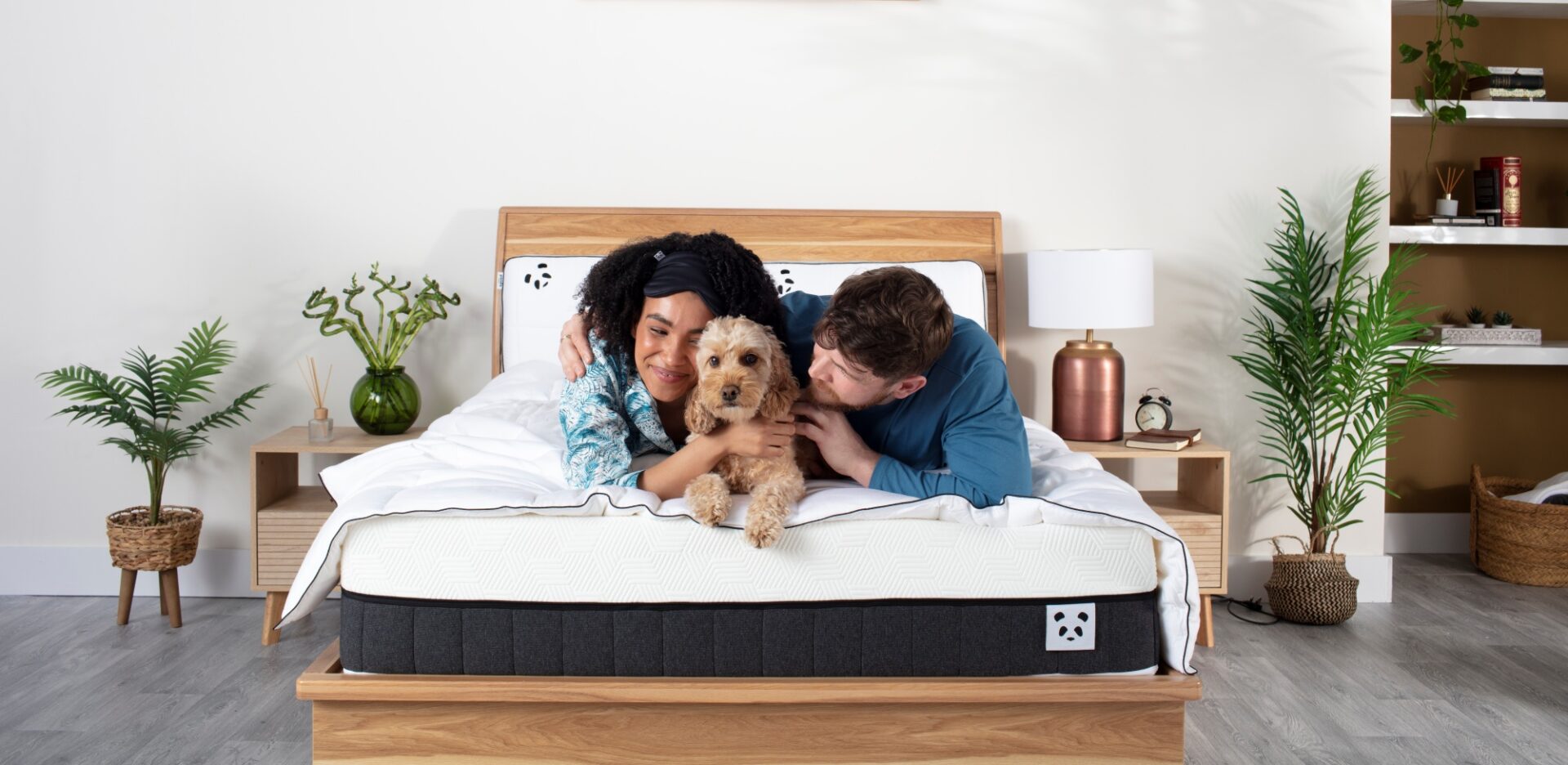 Couple with a dog laying on Panda Hybrid Mattress Pro