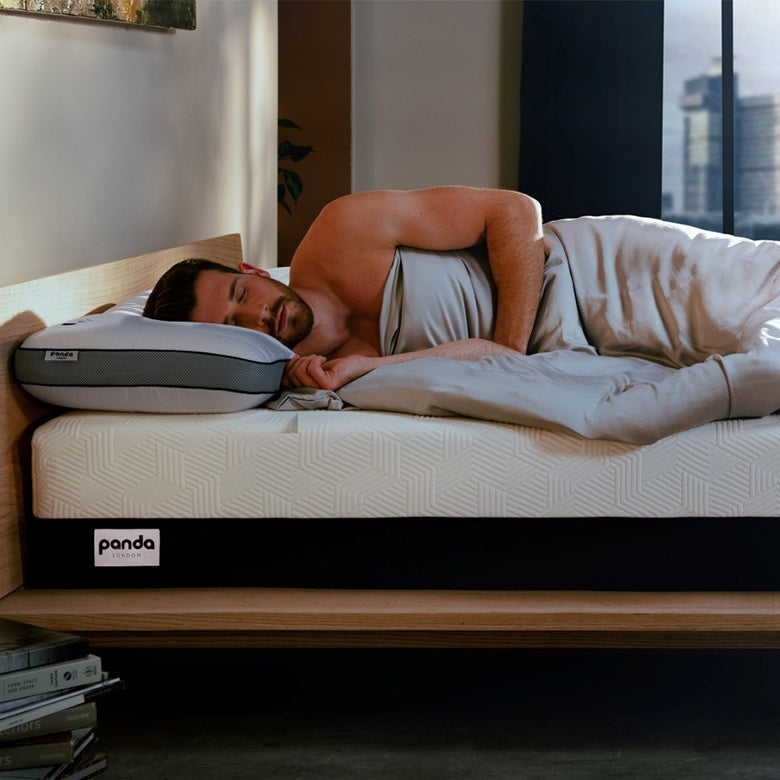Man peacefully sleeping on a Panda mattress, demonstrating relaxation and comfort for quality sleep.