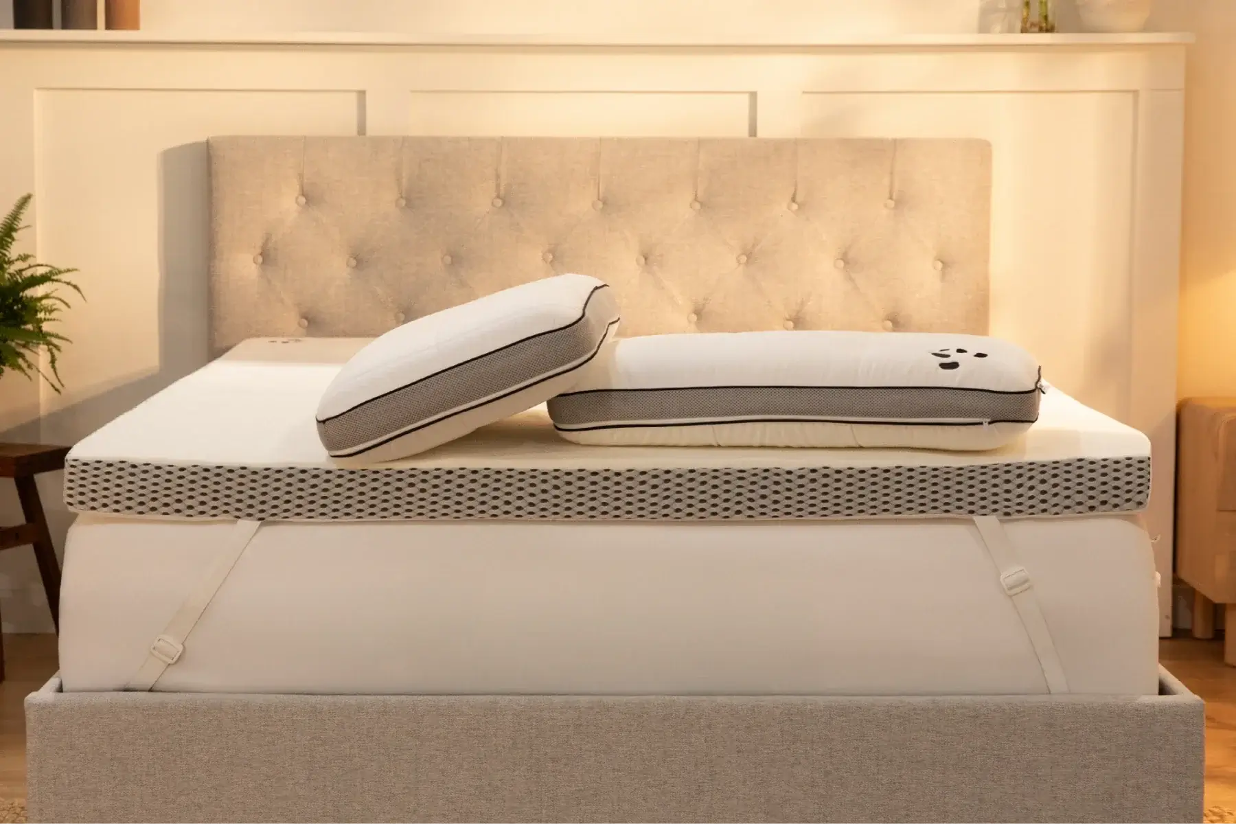Mattress topper on a bed with a neutral headboard in a bedroom setting