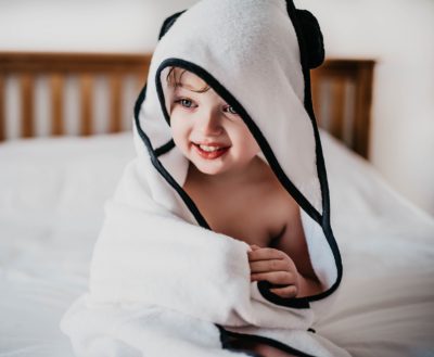 Child Smiling Wearing Panda London 100% Bamboo Hooded Towel In White