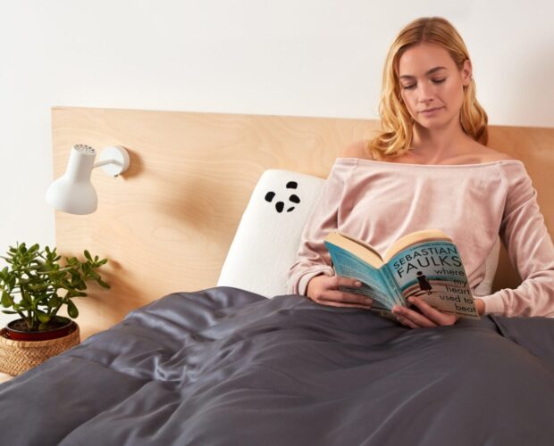Girl reading a book on a Panda pillow