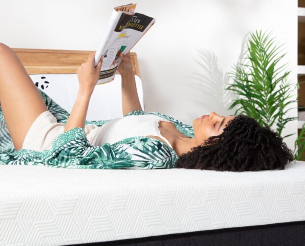 Hybrid Bamboo Mattress - Woman laying on the bed reading newspaper